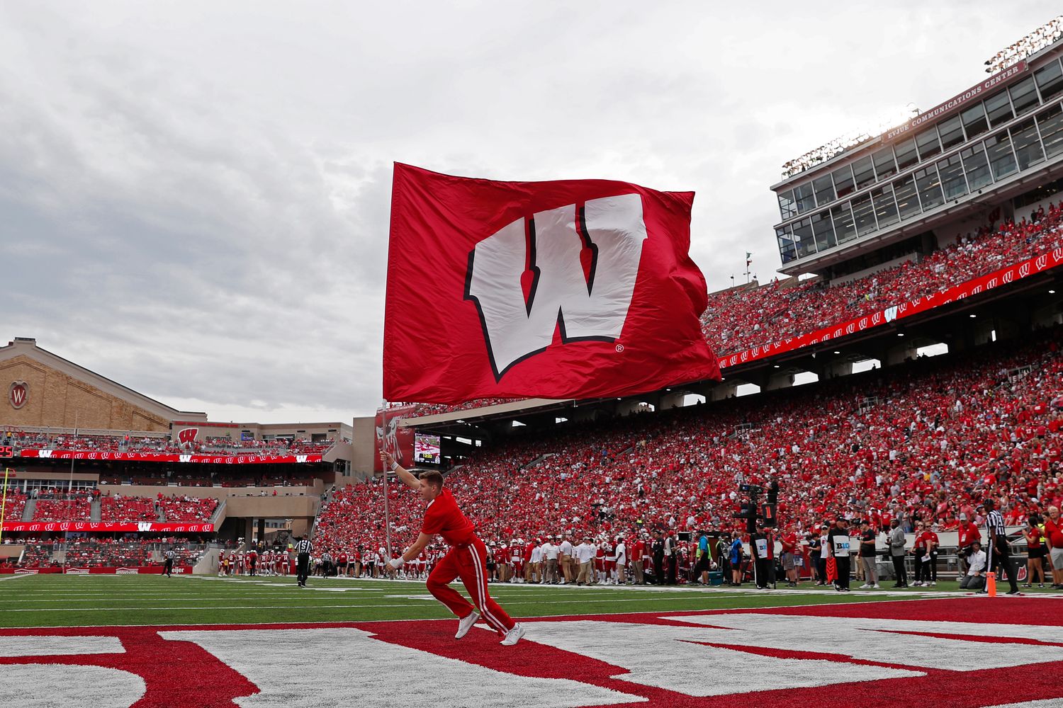 The Wisconsin flag being waved after a scoring play at Camp Randall Stadium.